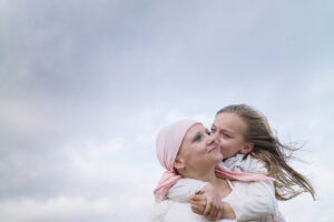 Woman with cancer hugging girl
